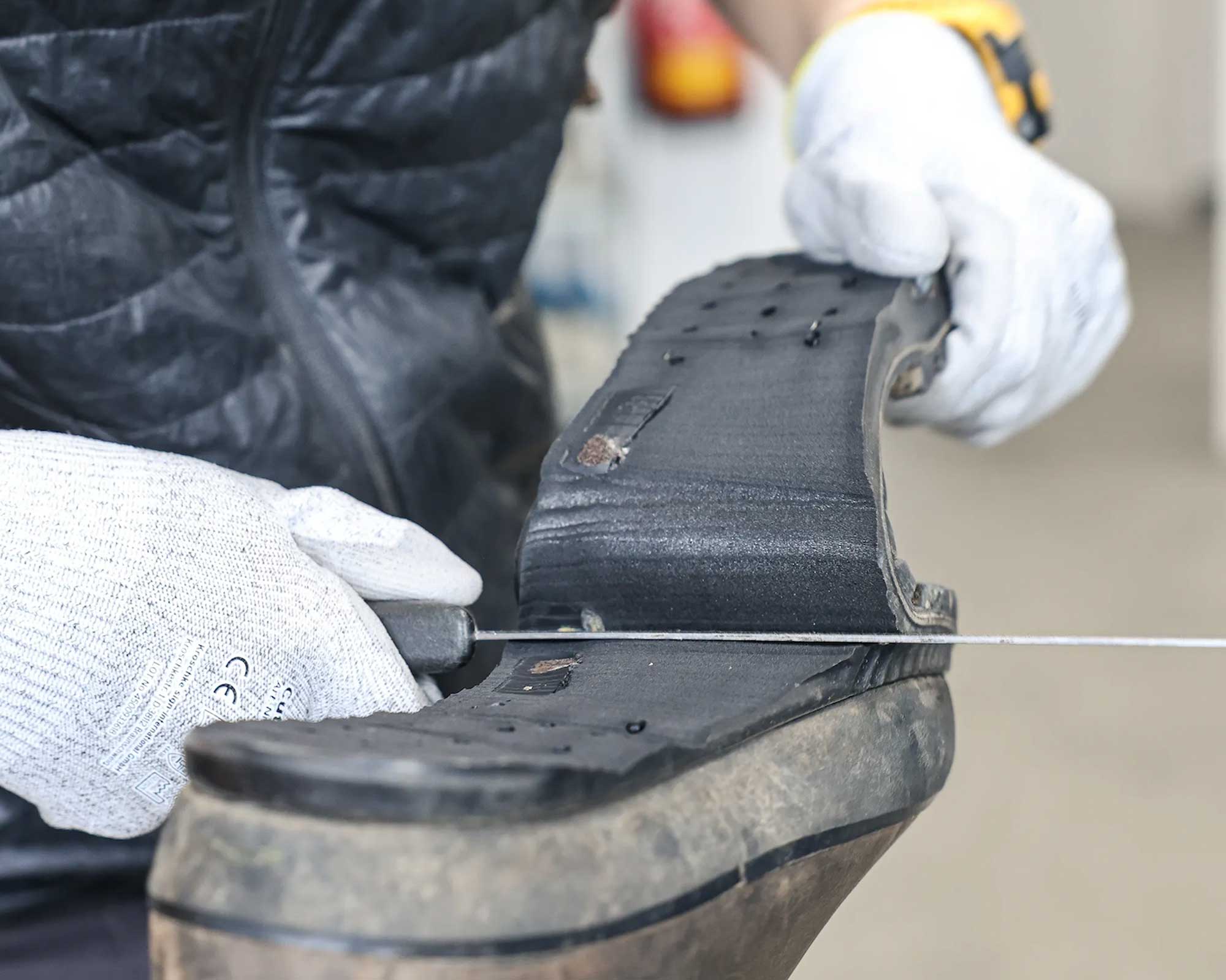 Erster Schritt der Neubesohlung, die alte wird runtergeschnitten © Hanwag