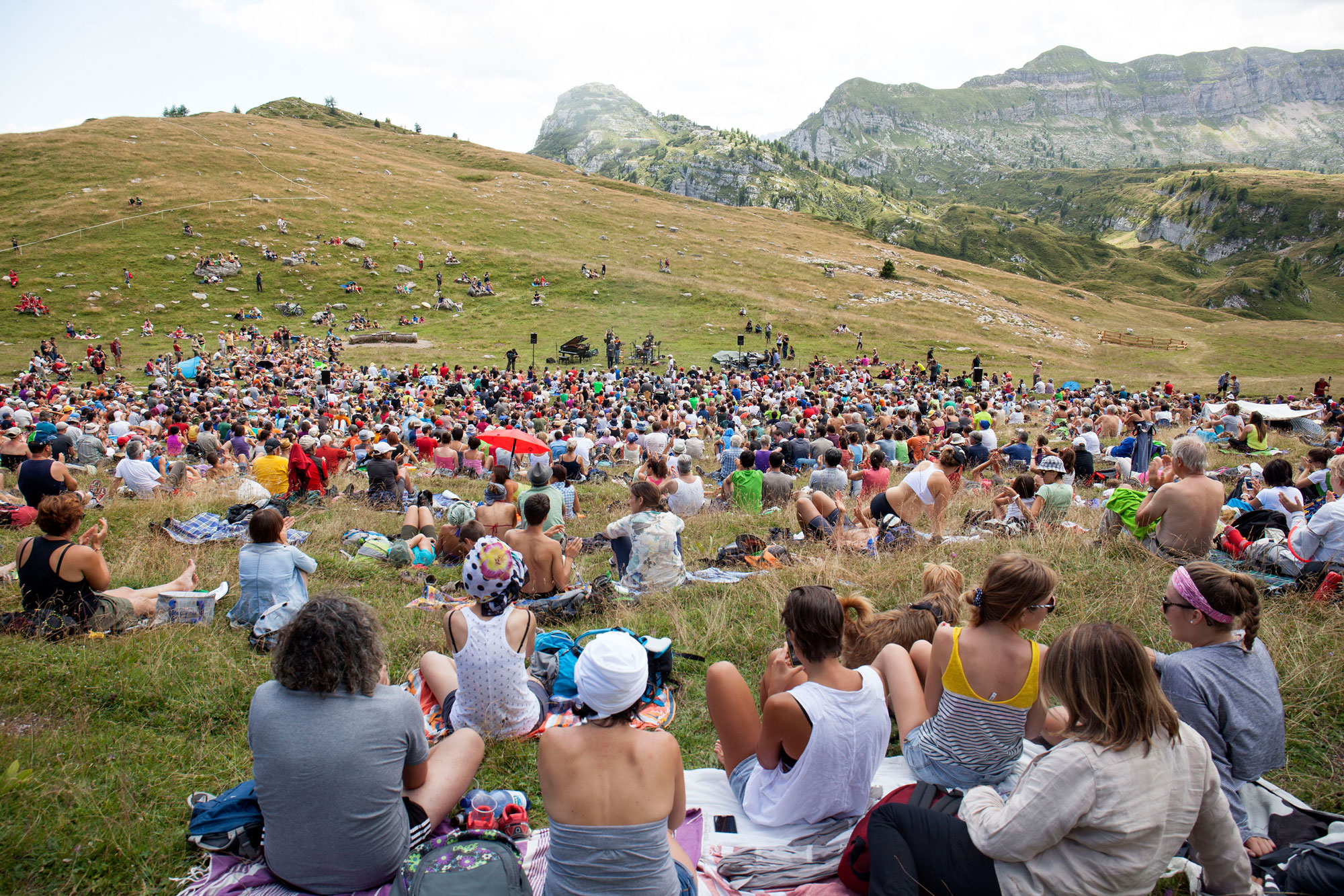 Publikum auf Picknickdecken vor Bergkulisse