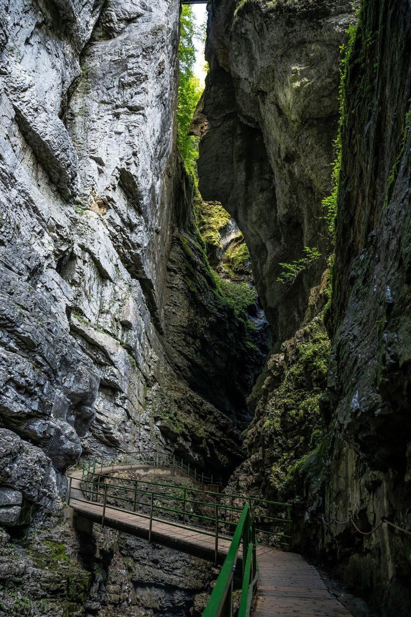 Schmale Felsspalte, durch die ein Holzweg mit Geländer führt.
