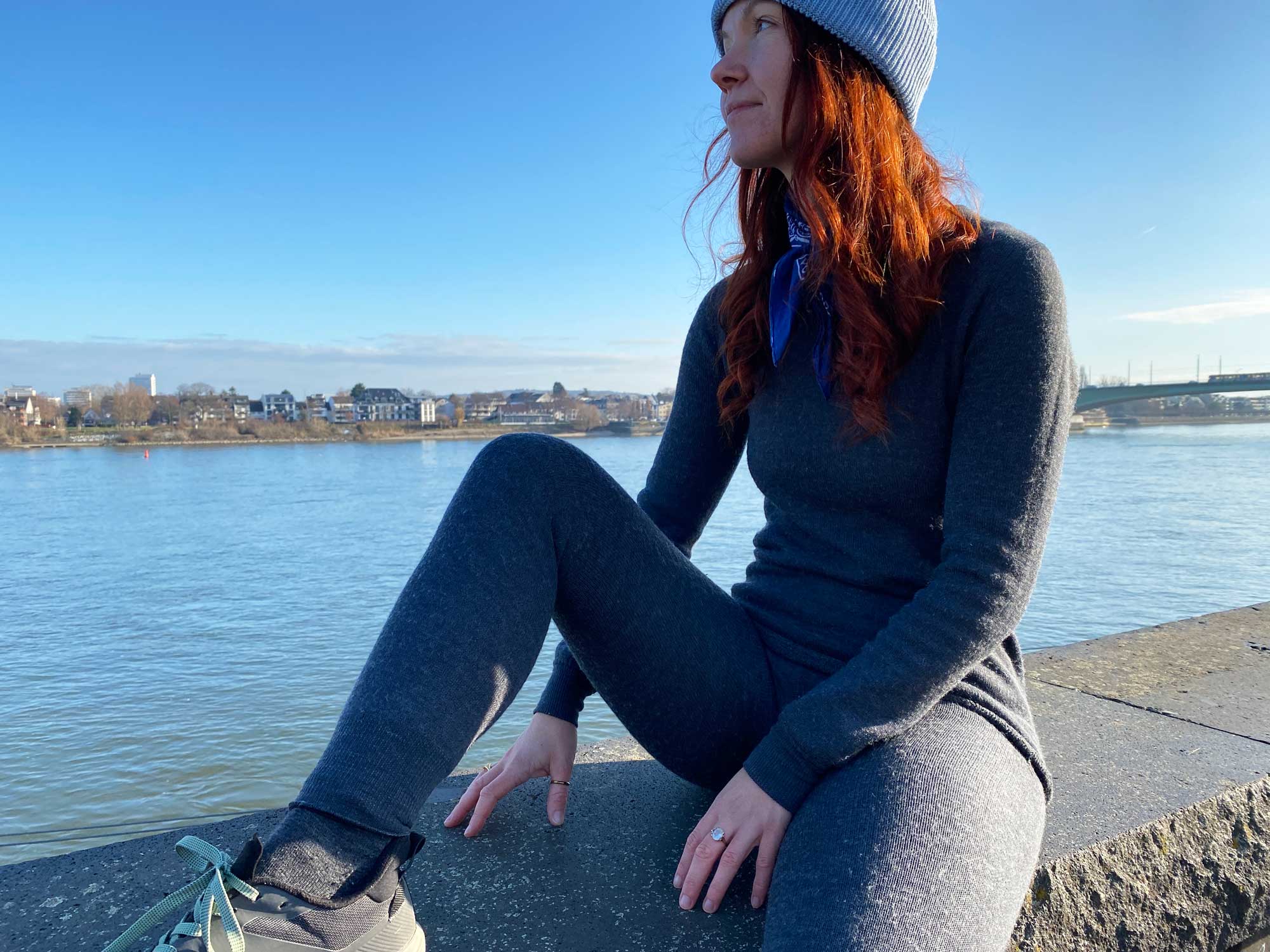Redakteurin Marieke sitzt am Fluss mit der Funktionsunterwäsche
