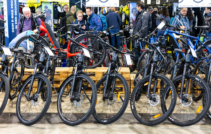 viele Fahrräder aufgereiht in einem Messebereich