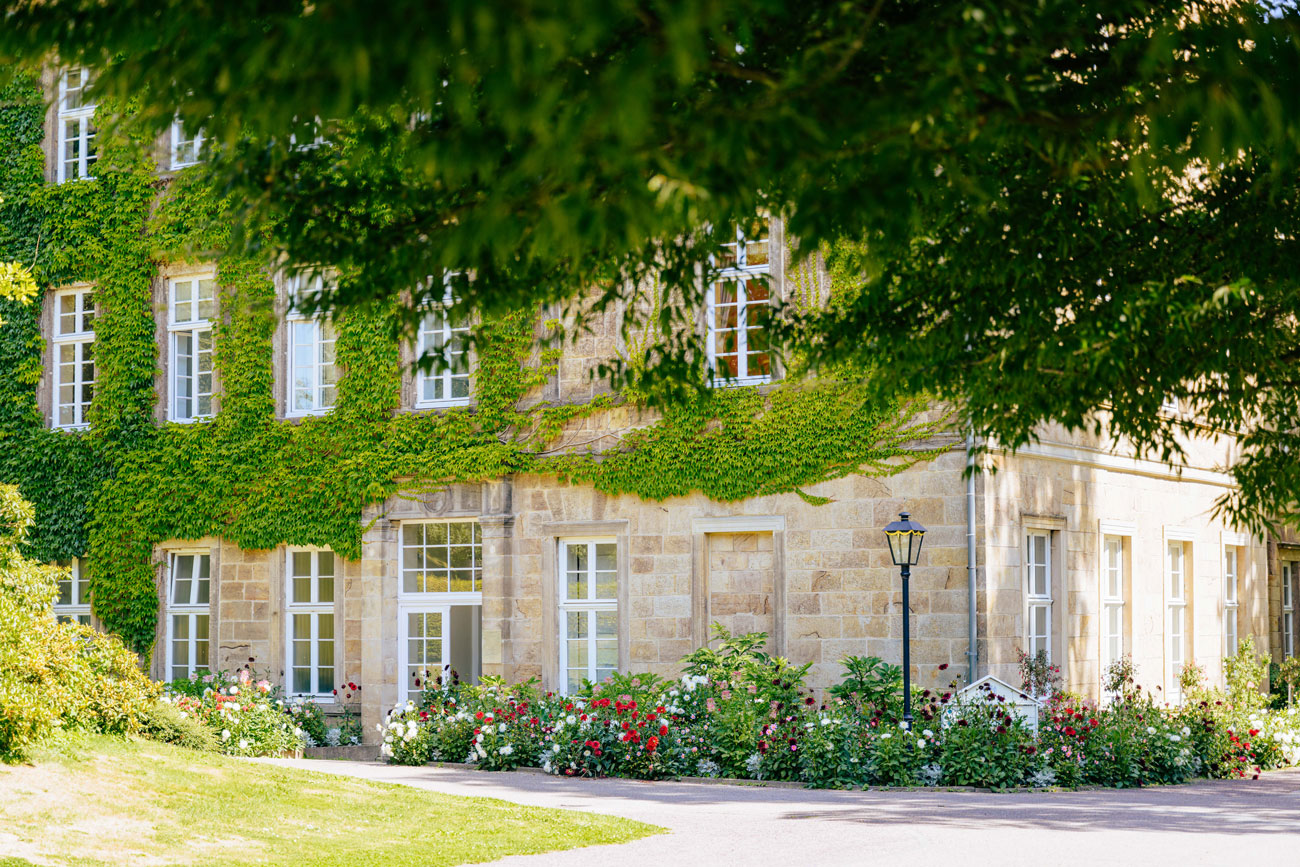 Detailaufnahme Steinhaus mit Blumenbeeten