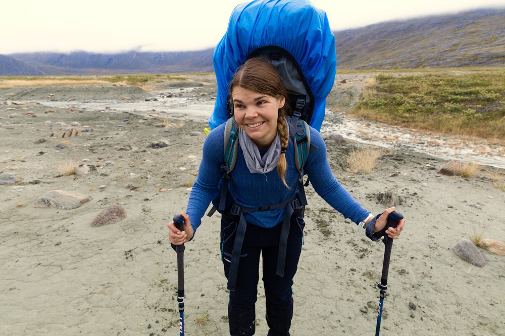 Die Autorin mit großem Rucksack erschöpft aber glücklich auf Trekkingstöcke gestützt
