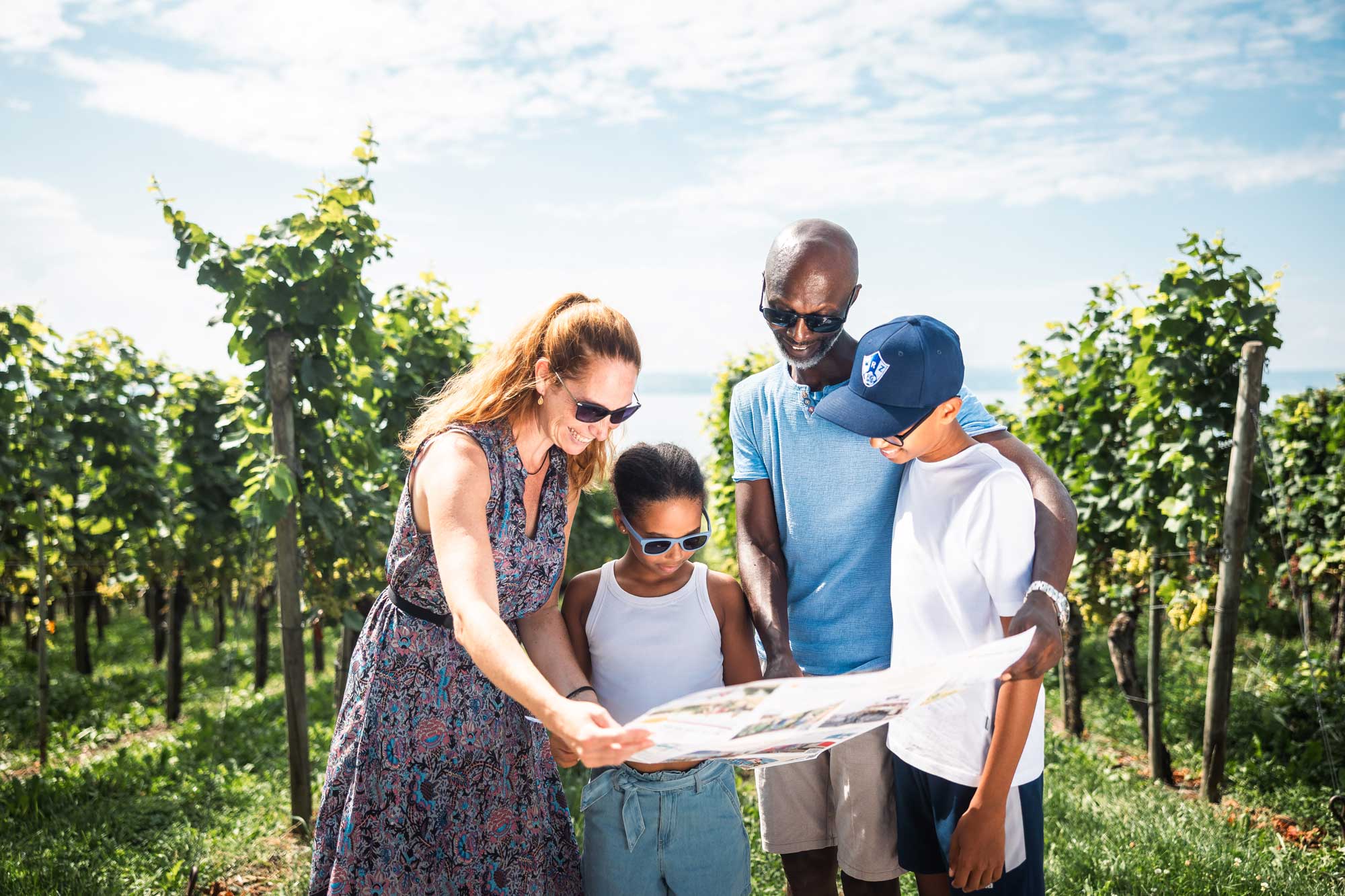 Eine Familie in den Weinbergen schaut auf eine Wanderkarte