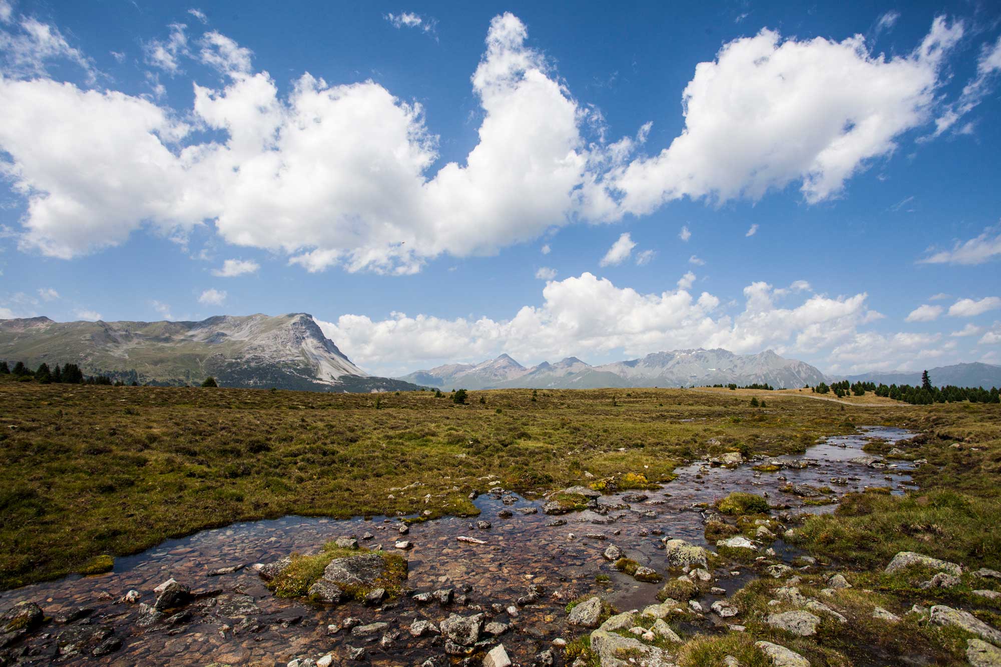 Eine Berglandschaft mit einem kleinen Bach im Vordergrund