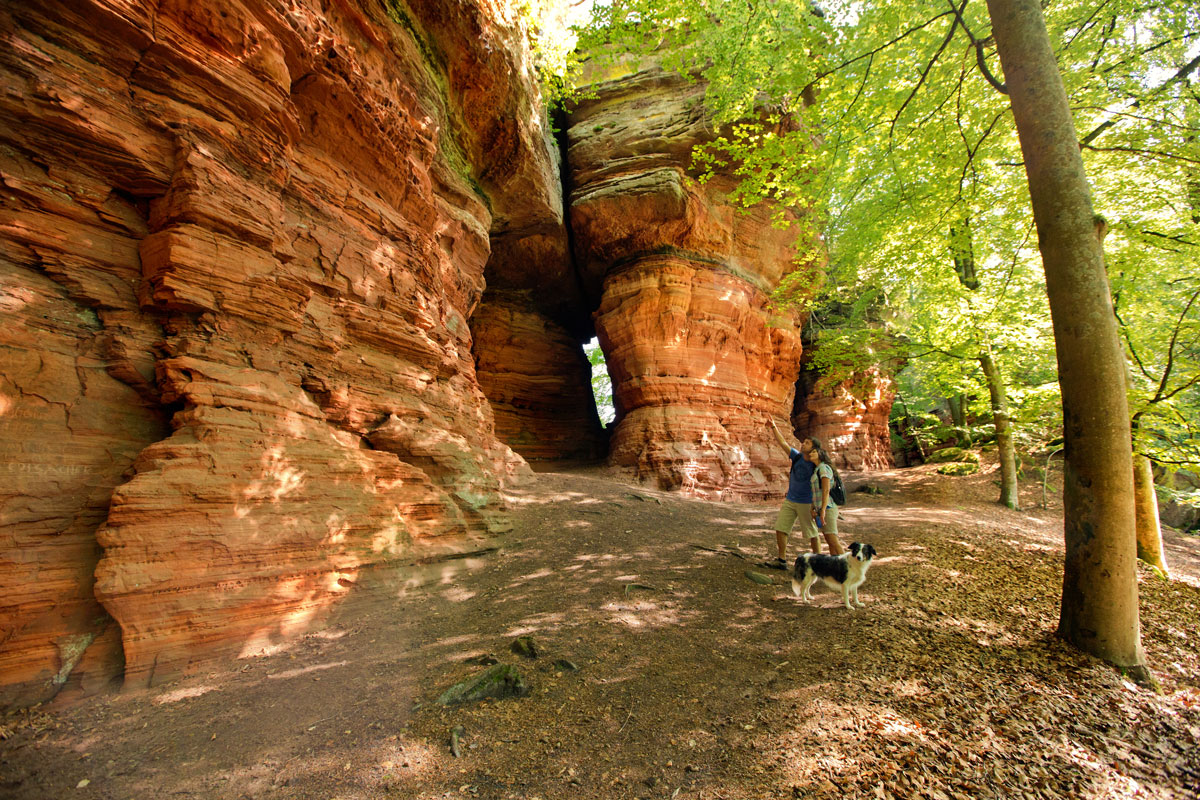 Felsenmassiv mit zwei Wandernden davor