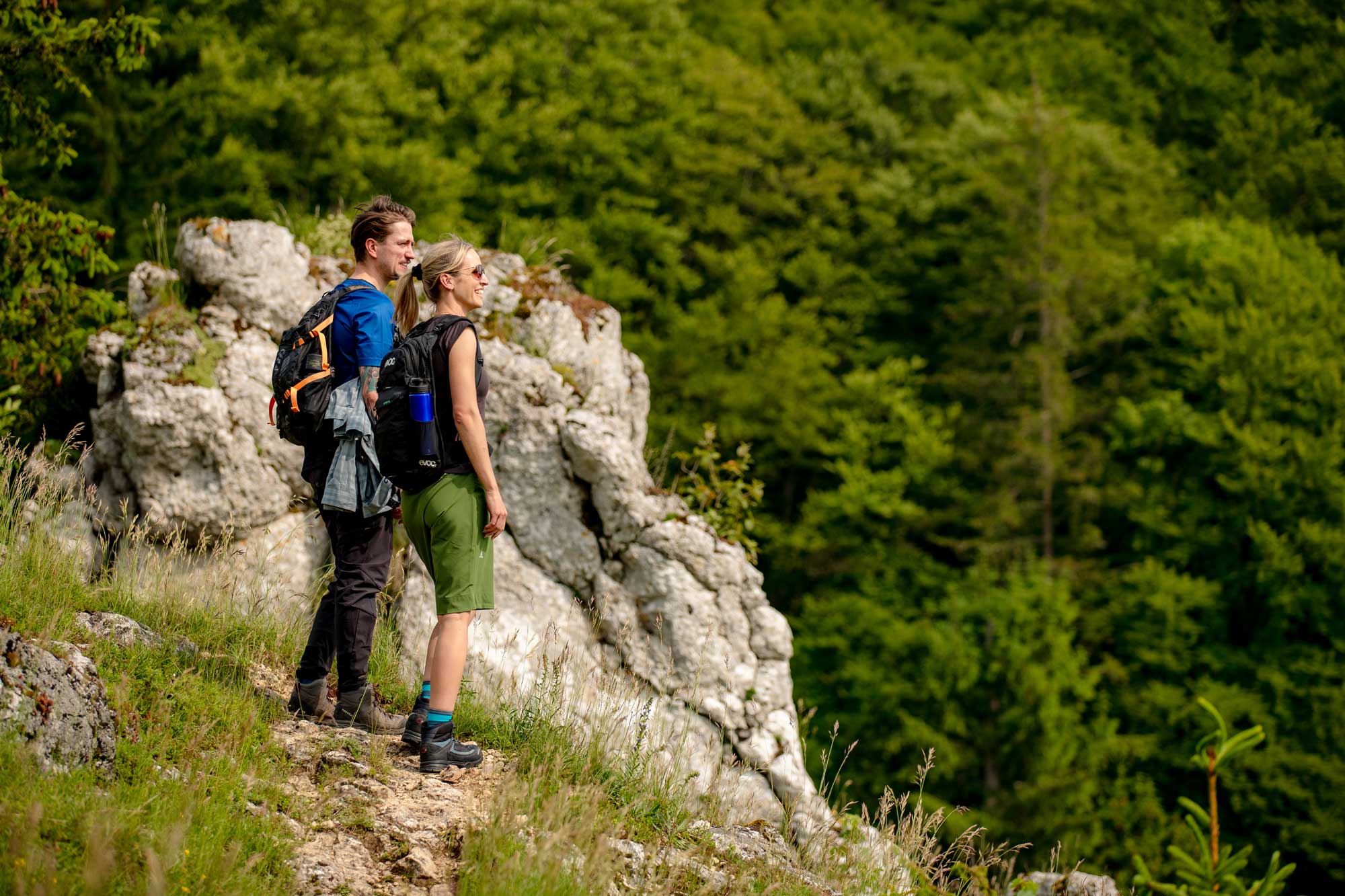 Zwei Wanderer stehen neben einem Felsen