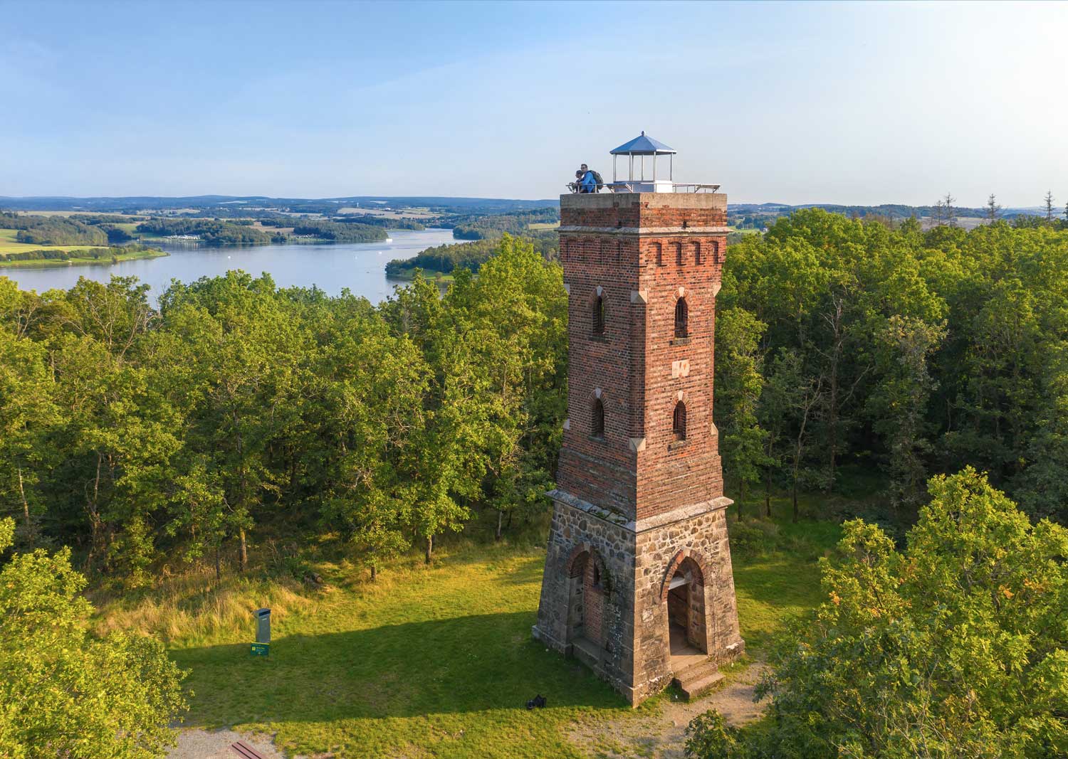 Ein Aussichtsturm aus Backsteinen mit Blick auf das Wasser der Talsperre