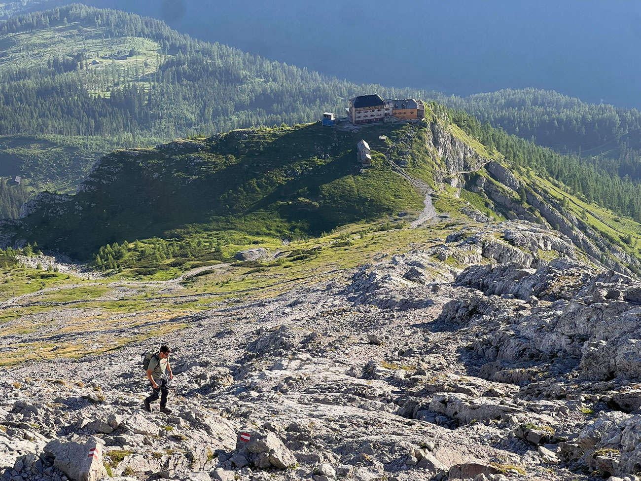 Wanderer im Hang im Hintergrund eine Berghütte