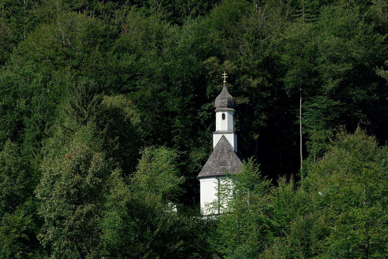 Kleine Kirche ragt aus bewaldeten Hang