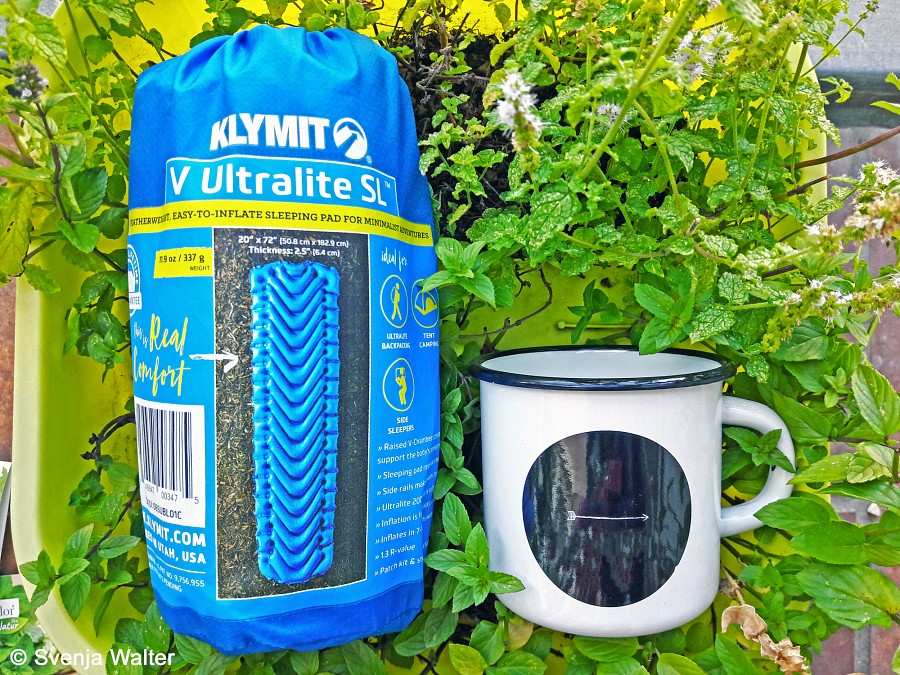 Größenvergleich der verpackten Schlafmatte mit einer Tasse