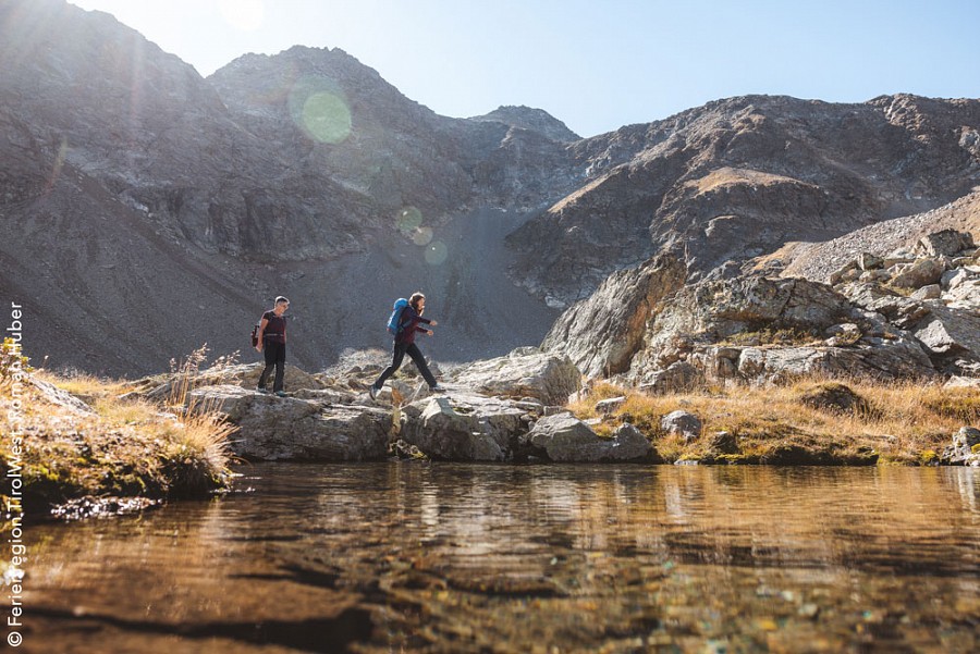 Zwei Wandernde am Ufer eines Bergsees