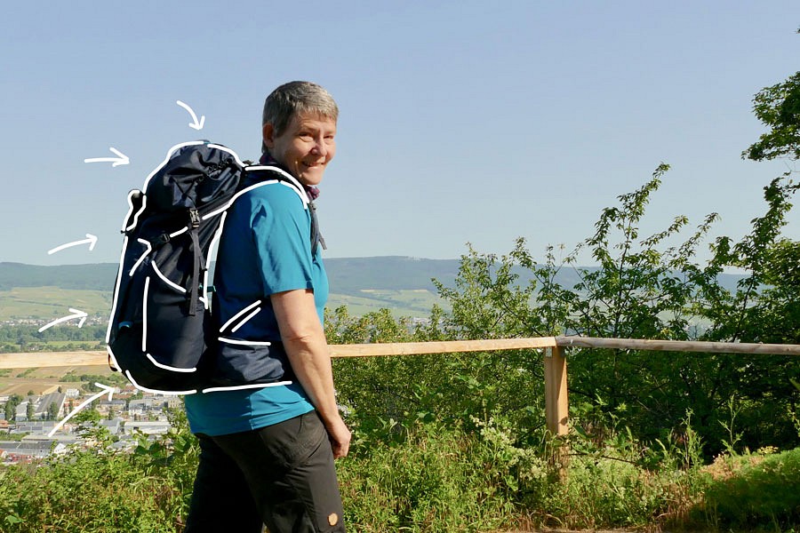 Frau mit Rucksack an einem Aussichtspunkt