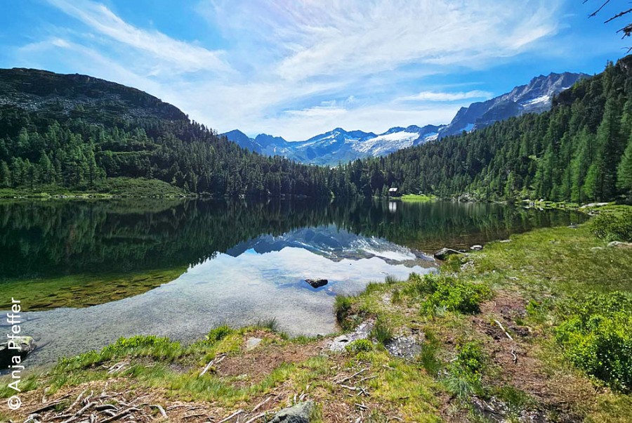 Ein Bergsee mit Spiegelbild der umliegenden Gipfel