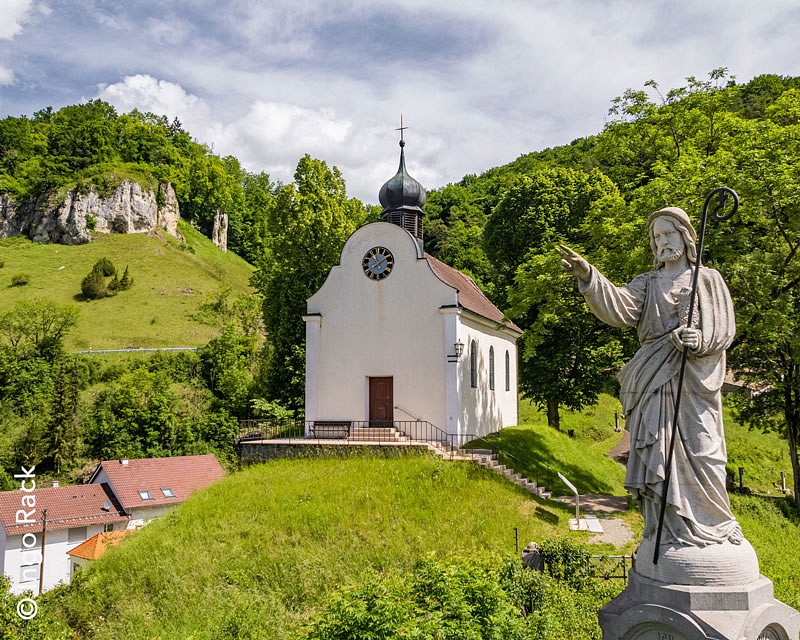 Eine Kapelle und Hirtenstatue im Grünen