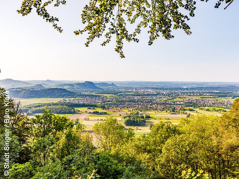 Weitblick auf Ortschaften zwischen Feldern und Hügelkette im Hintergrund 