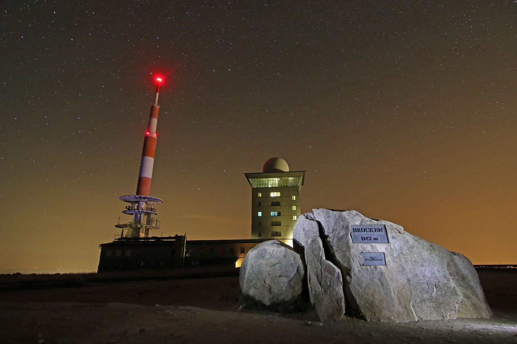 pDer-Gipfelstein-auf-dem-Brocken-mit-der-Houmlhenangabe-1142-Meter-Sie-bezieht-sich-auf-die-Markierungslinie-darunter-Die-amtliche-Houmlhe-des-Brockens-betraumlgt-1141-Meterp