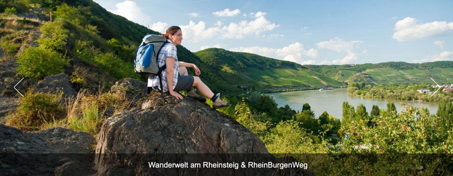 Frau mit Rucksack sitzt auf einem Felsvorsprung hoch über einem Fluss