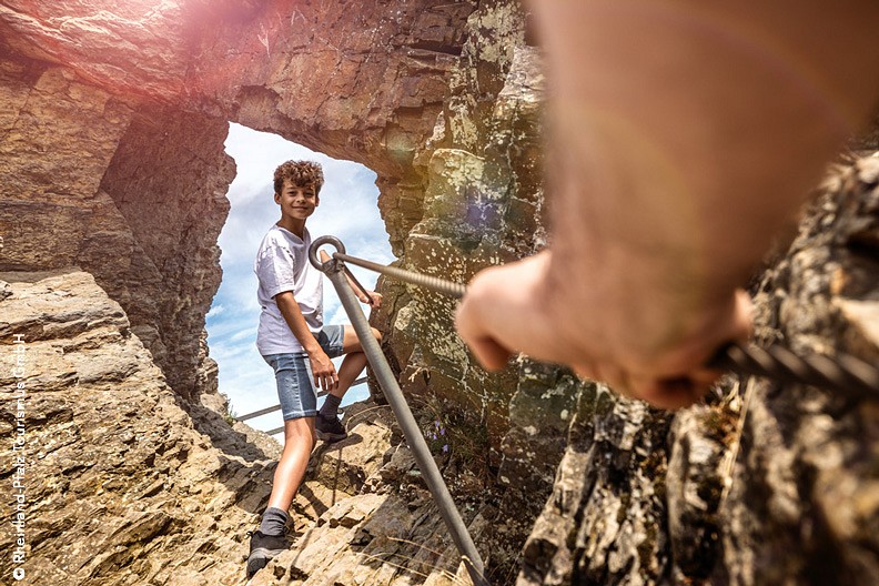 Ein Kind steht vor einem Loch in der Felswand