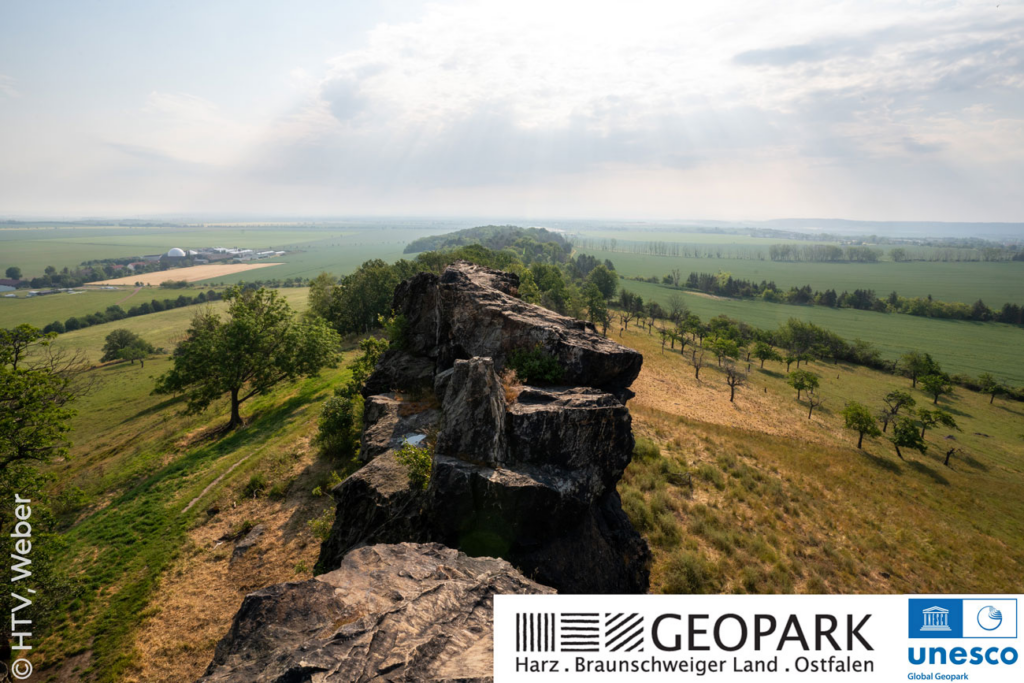 Markante Felsen ziehen sich ein einer Kette über einen Hügelkamm, rundherum erstrecken sich weite offene Wiesen bis zum Horizont.
