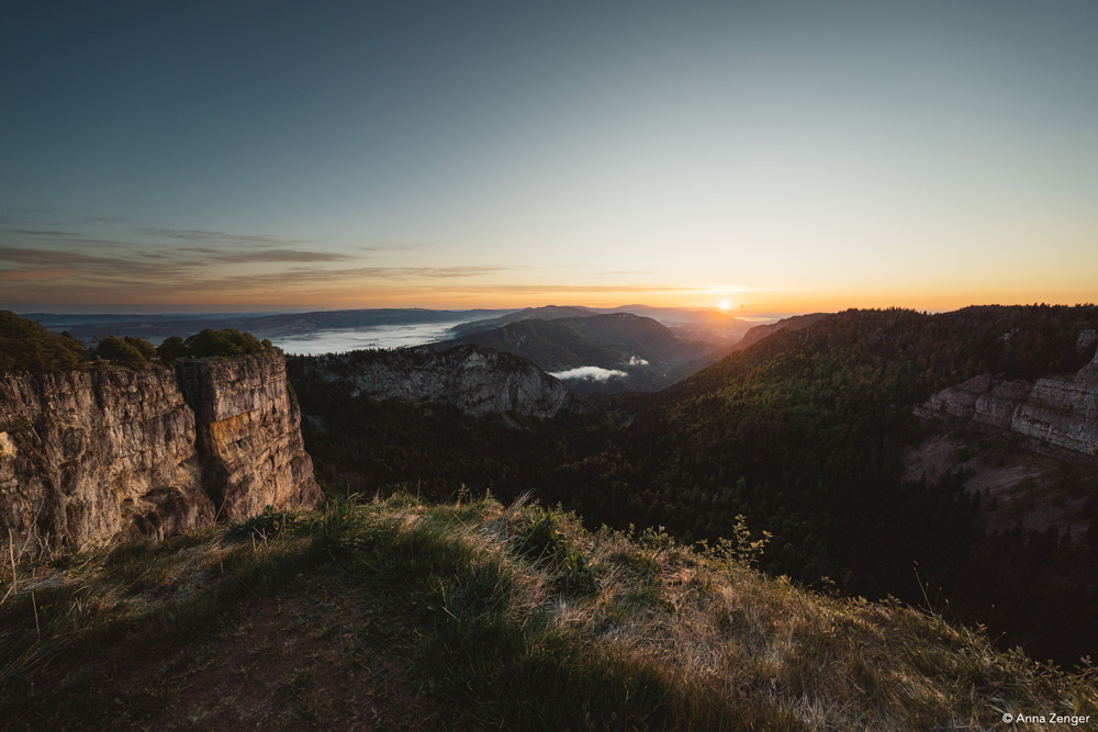Sonnenaufgang über einem tiefen Tal von Felswänden eingerahmt
