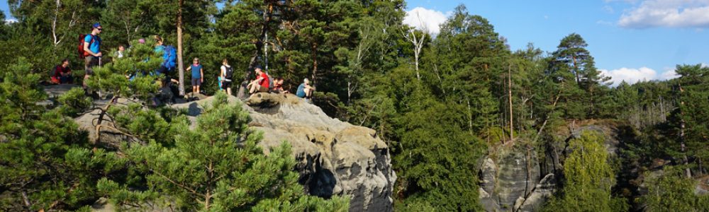 Gruppe Menschen auf einem exponierten Fels im Wald